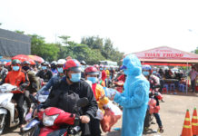 Lực lượng chức năng huyện Chư Pưh trao các suất ăn, nước uống cho công dân trước khi xuất phát. Ảnh: Quang Tấn
