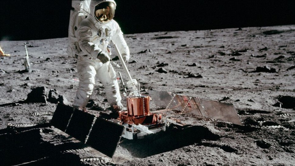  Phi hành gia đặt một thiết bị lên bề mặt Mặt trăng. Ảnh: NASA