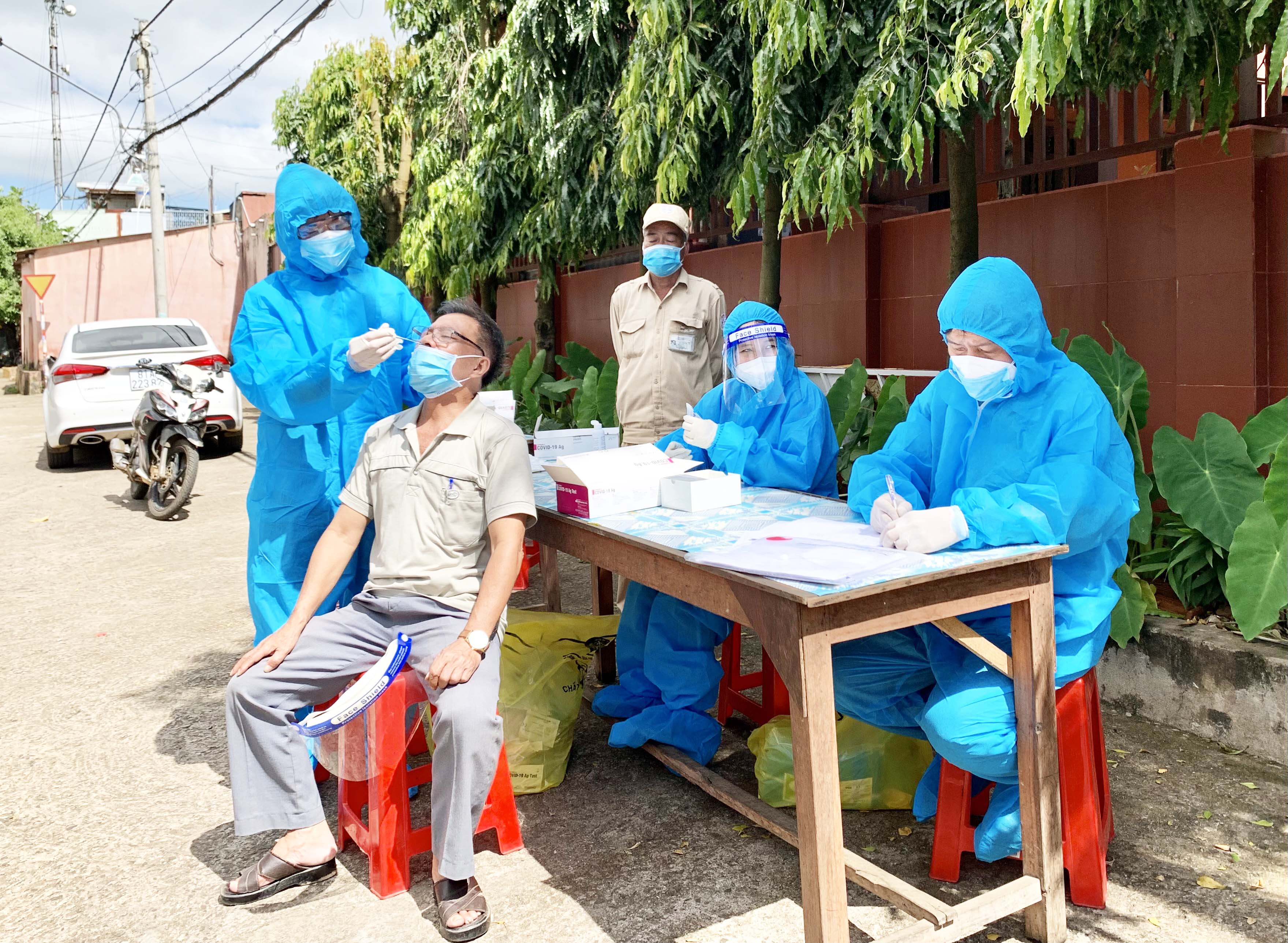 Nhân viên y tế lấy mẫu xét nghiệm cho người dân khu vực chợ Bà Định. Ảnh: Như Nguyện