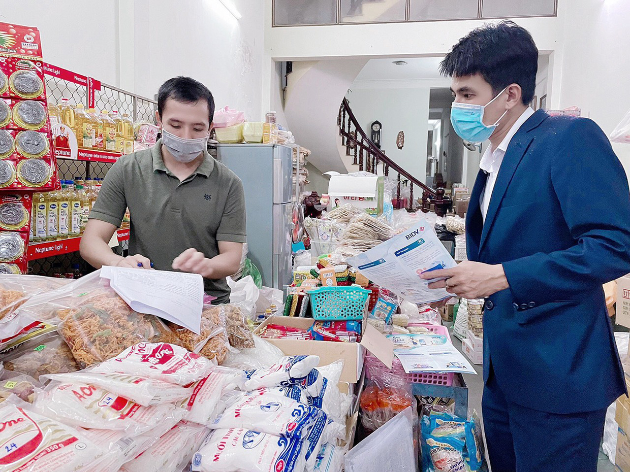  Cán bộ tín dụng BIDV Gia Lai giới thiệu với khách hàng về gói sản phẩm ưu đãi dành cho tiểu thương, hộ kinh doanh. Ảnh: Sơn Ca