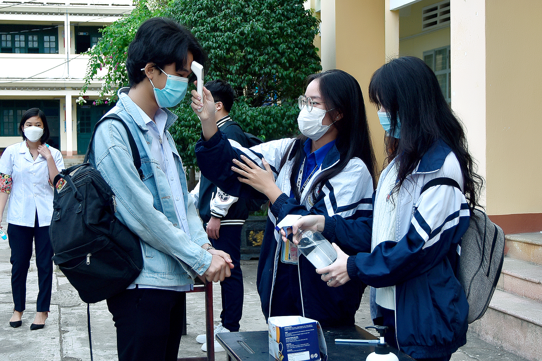 Học sinh Trường THPT Lê Lợi thực hiện đo kiểm tra thân nhiệt trước khi vào lớp. Ảnh: Đức Thụy