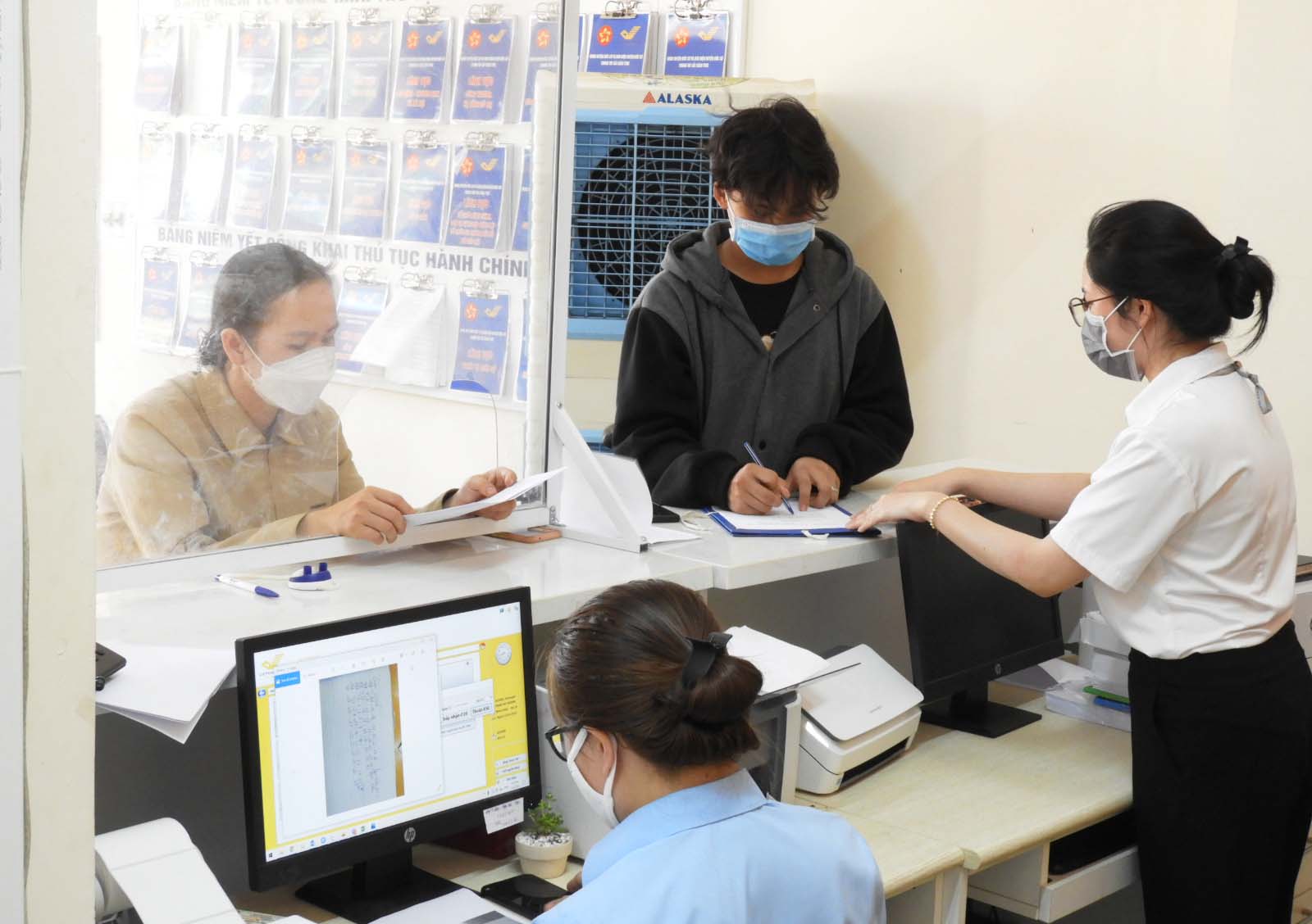 Cán bộ tiếp nhận hướng dẫn công dân bổ sung thông tin hồ sơ thủ tục hành chính. Ảnh: Thanh Nhật