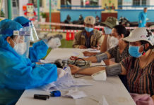 Nhân viên y tế kiểm tra huyết áp người dân trước khi tiêm vắc xin phòng Covid-19 tại điểm tiêm Trường Mầm non Mai Vàng (phường Phù Đổng, TP. Pleiku). Ảnh: Bá Bính