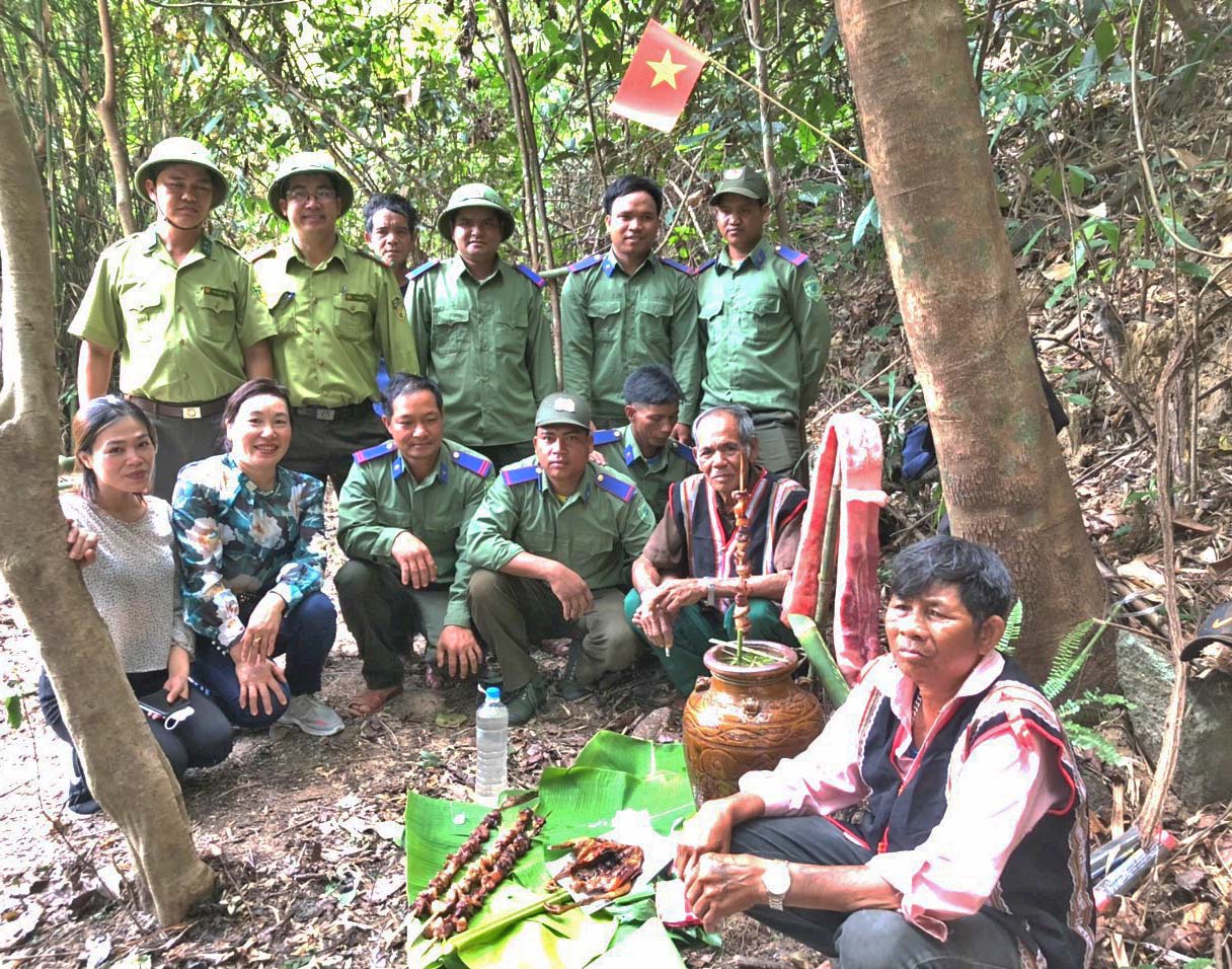 Đại diện lãnh đạo Huyện ủy cùng lực lượng kiểm lâm chụp ảnh lưu niệm với già làng thực hiện nghi lễ cúng rừng. Ảnh: Đinh Yến