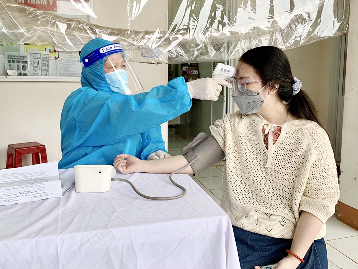 Nhân viên y tế phường Ia Kring (TP. Pleiku) khám sàng lọc trước khi tiêm vắc xin phòng Covid-19 cho người dân từ 18 tuổi trở lên trên địa bàn. Ảnh: Như Nguyện