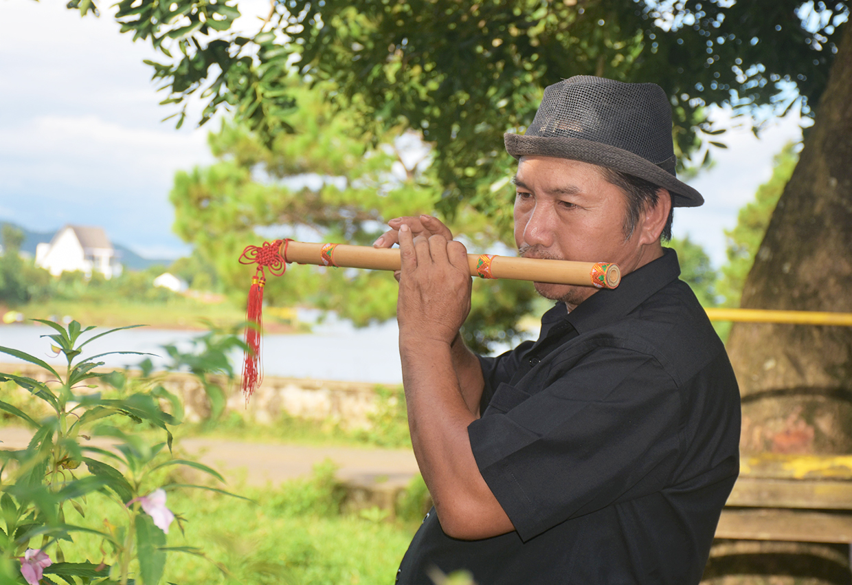  Tiếng sáo của ông Nguyễn Văn Lợi đã “níu chân” nhiều du khách khi tới tham quan danh thắng Biển Hồ. Ảnh: Mai Ka