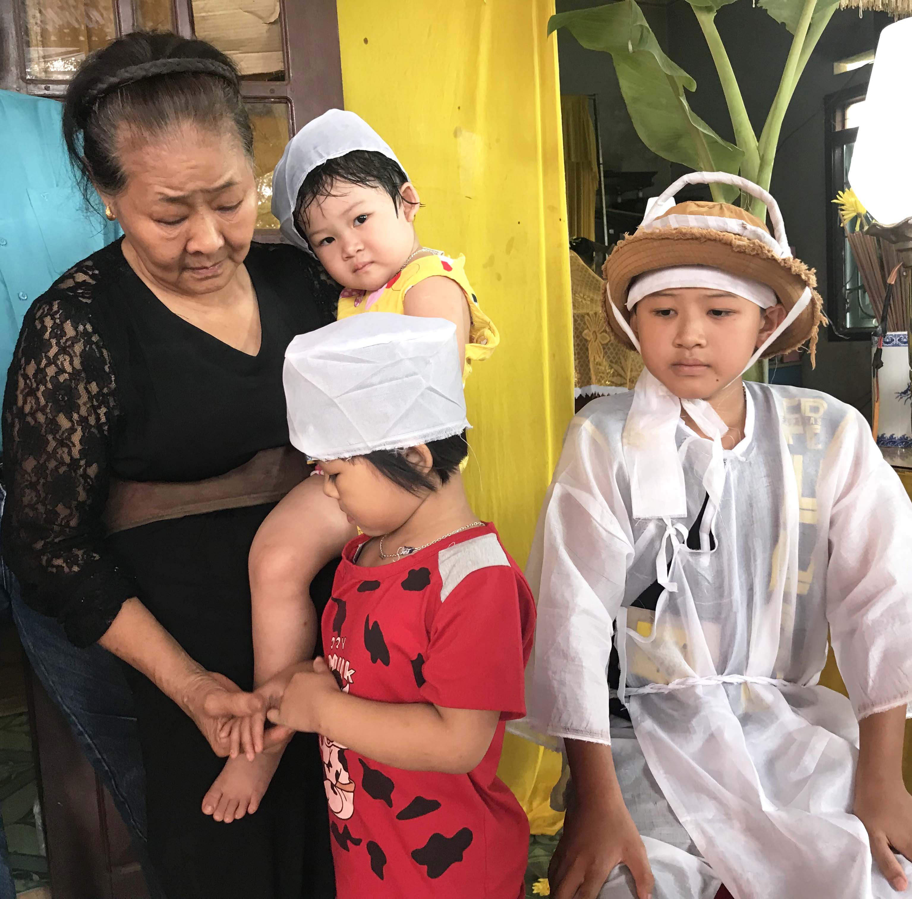 Bà Nguyễn Thị Thưởng cùng 3 cháu nội. Ảnh: Lê Gia