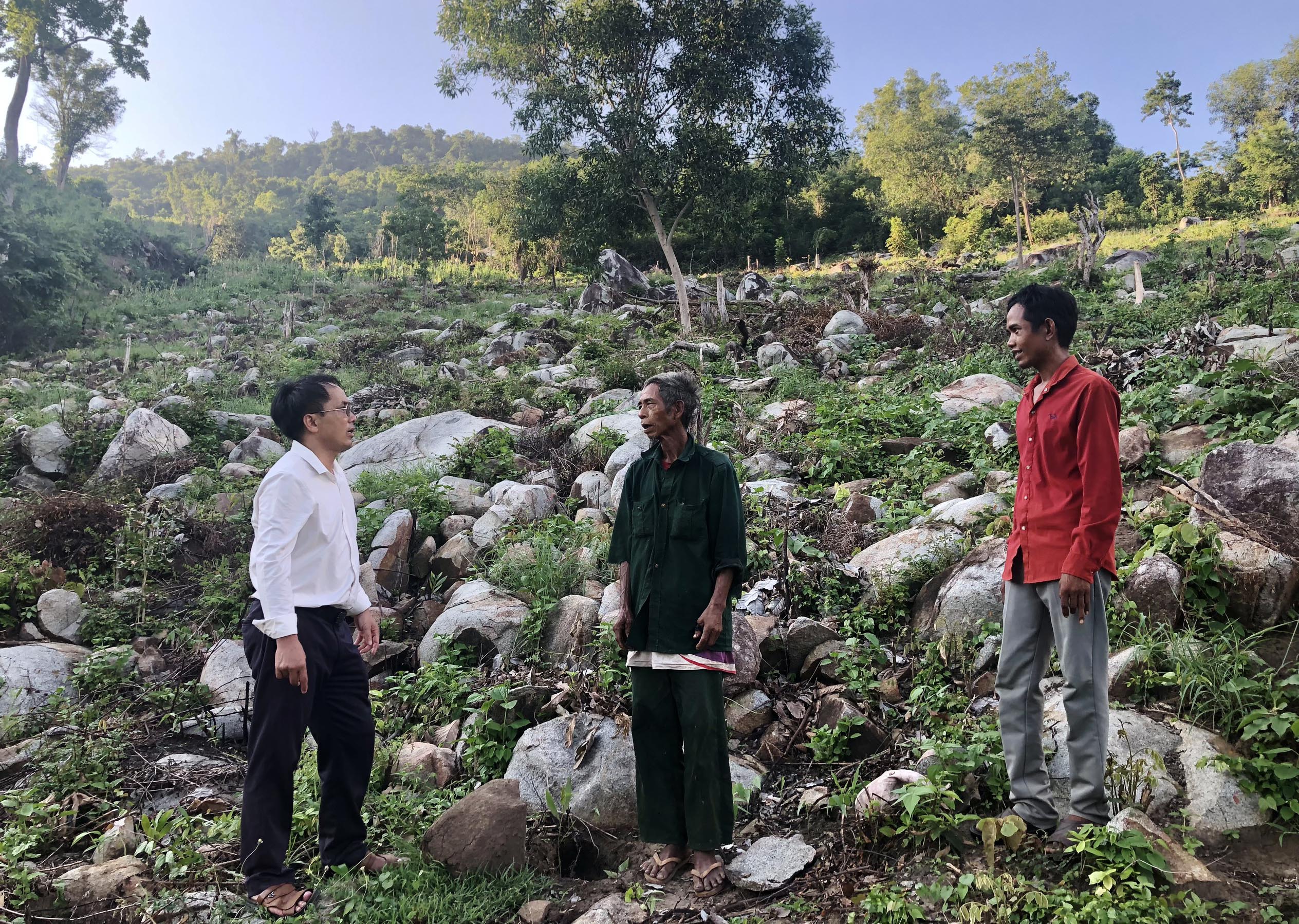 Ông Trịnh Thanh Khiết-Bí thư Đảng ủy xã Đất Bằng (bìa trái) trao đổi với người dân về chuyển đổi đất nương rẫy sang trồng rừng. Ảnh: Lê Nam