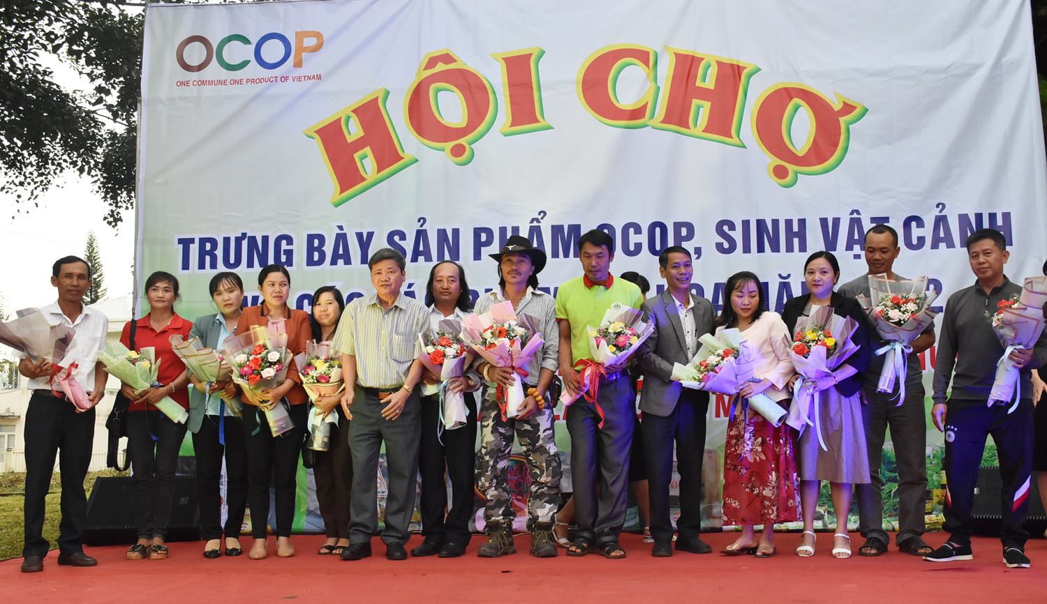Lãnh đạo huyện Mang Yang tặng hoa cho các đơn vị tham gia tại hội chợ triển lãm. Ảnh: Hà Phương