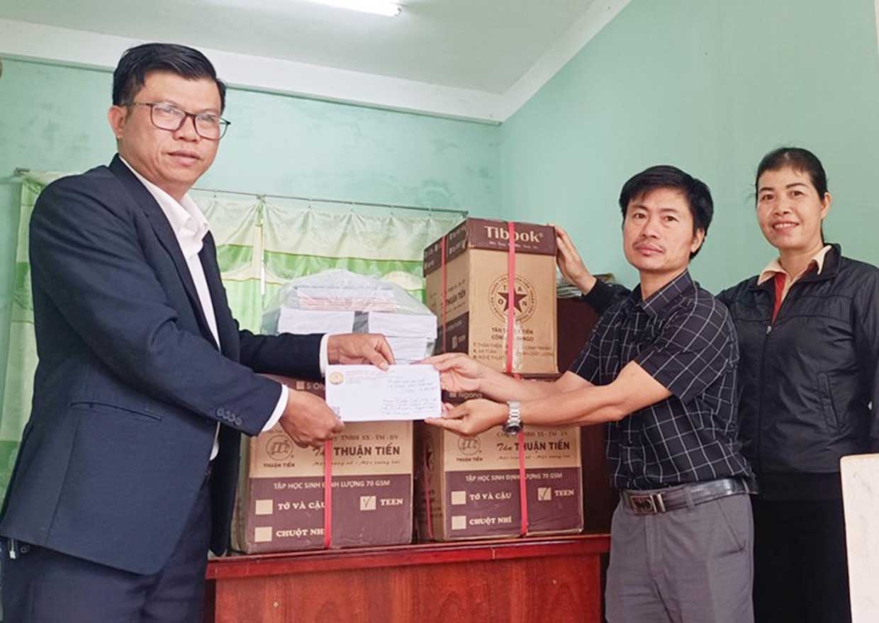   Thầy Phan Ngọc Duy (bìa trái) trao vở và tiền mặt vận động từ các Mạnh Thường Quân cho Trường Tiểu học và THCS Trần Hưng Đạo (xã Ia Rong, huyện Chư Pưh). Ảnh: N.D