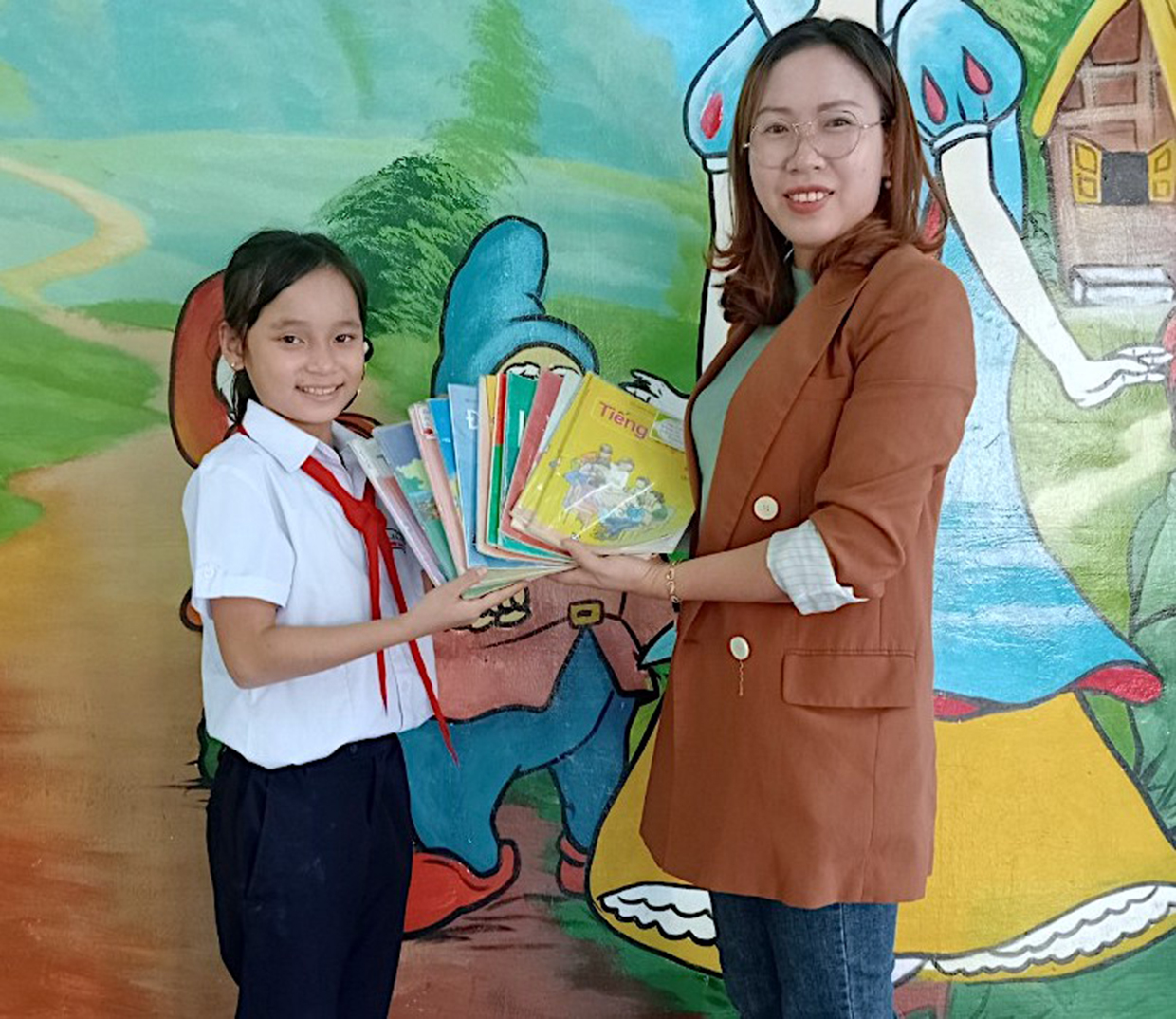  Em Hoàng Trần Ngọc Bích (lớp 5C, Trường Tiểu học Ia Nhin, huyện Chư Păh) tặng sách giáo khoa đã sử dụng cho tủ sách dùng chung của trường. Ảnh: Mộc Trà