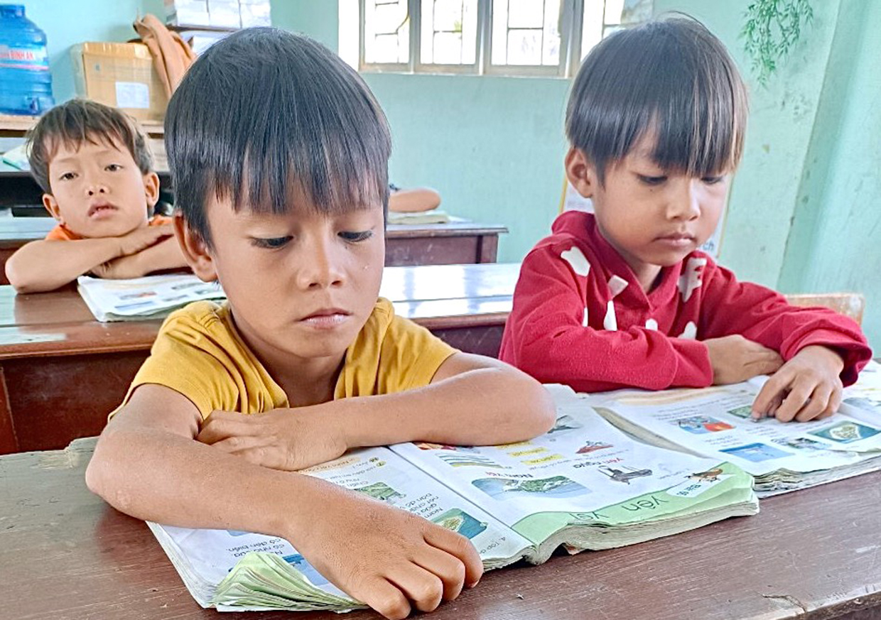   Học sinh lớp 1 của Trường Phổ thông Dân tộc Bán trú Tiểu học và THCS Sró (huyện Kông Chro) sử dụng sách giáo khoa từ Tủ sách dùng chung để học tập. Ảnh: Mộc Trà