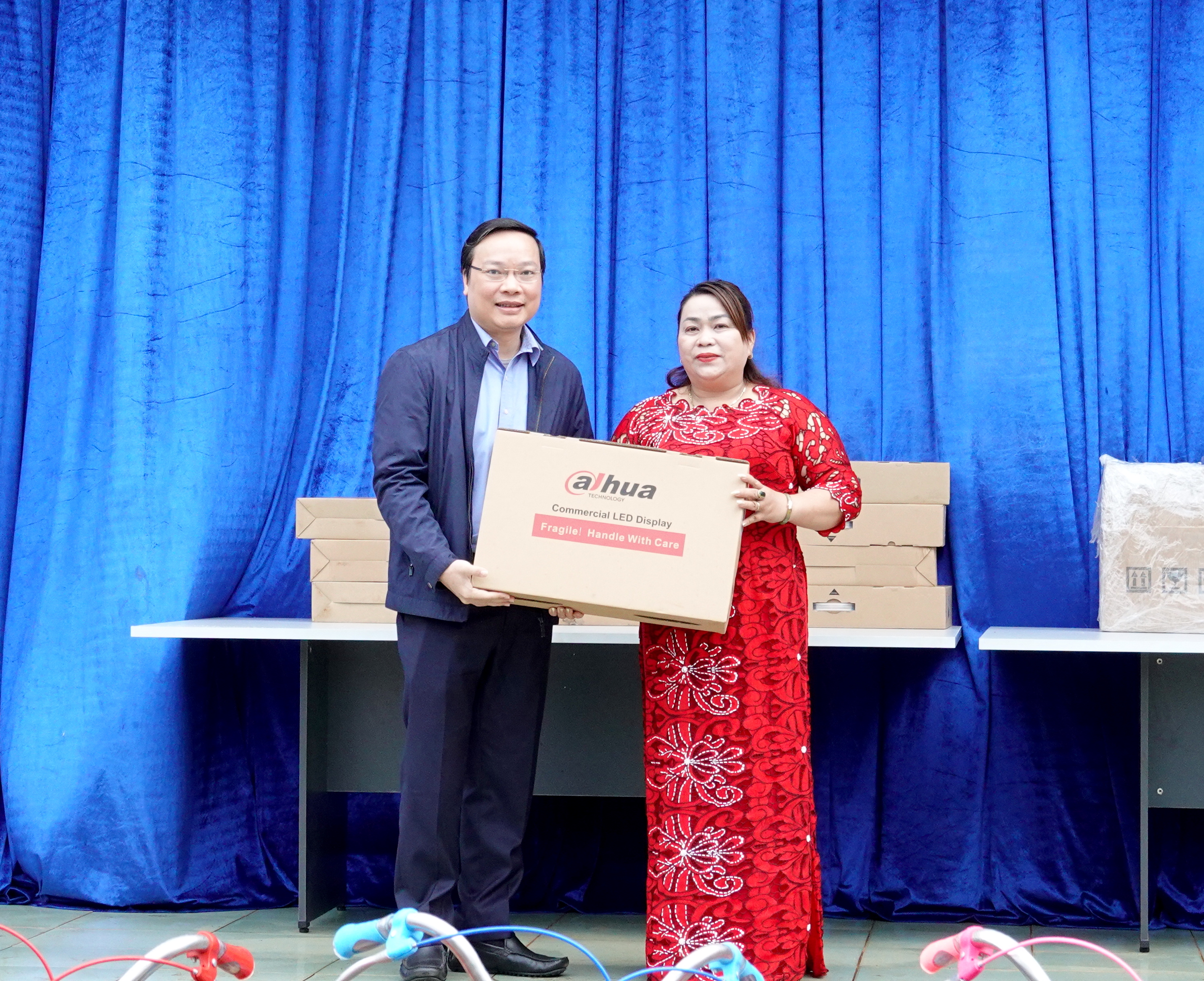 Cô Nguyễn Thị Thảo (bìa phải)-Hiệu trưởng Trường Tiểu học và THCS Anh Hùng Đôn đón nhận  phần quà là 8 bộ máy vi tính từ Chủ tịch UBND tỉnh Trương Hải Long trao tặng. Ảnh: Mộc Trà