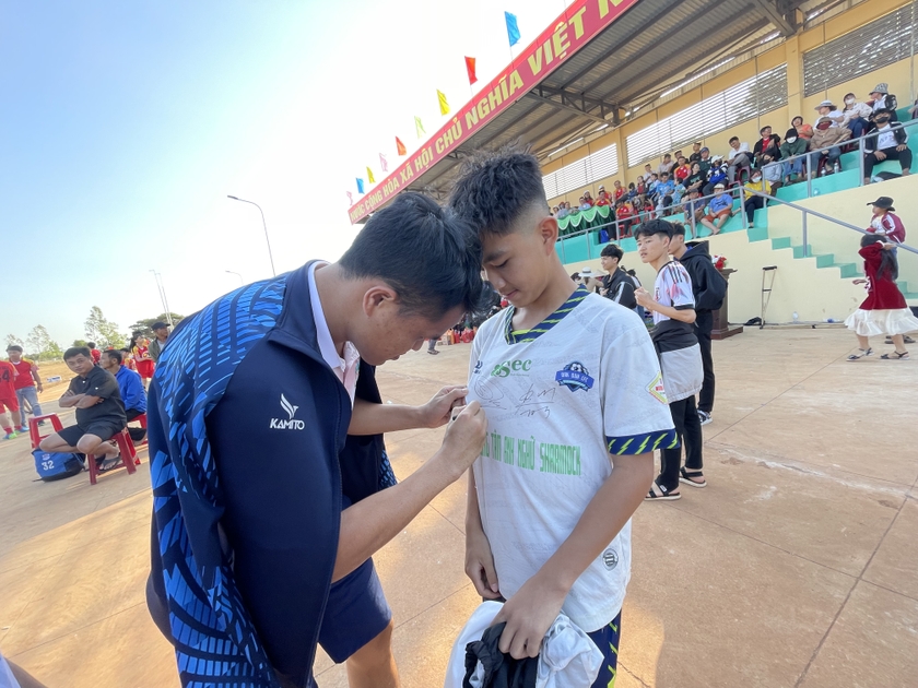 Các cầu thủ LPBank HAGL ký tặng áo cho người hâm mộ huyện Đak Đoa. Ảnh: Văn Ngọc
