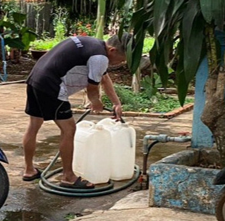 Người dân huyện Chư Sê phải xách can đi xin nước sinh hoạt do nhà máy nước nợ tiền điện, bị cắt điện sản xuất, dẫn đến không cấp nước được cho khách hàng - Ảnh: V.T.  2