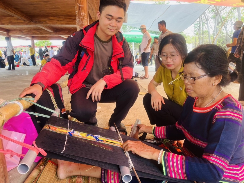 Anh Nguyễn Sơn Dương (xã Ia Băng, huyện Chư Sê) chiêm ngưỡng các nghệ nhân dệt thổ cẩm tại Ngày hội. Ảnh: Vũ Chi