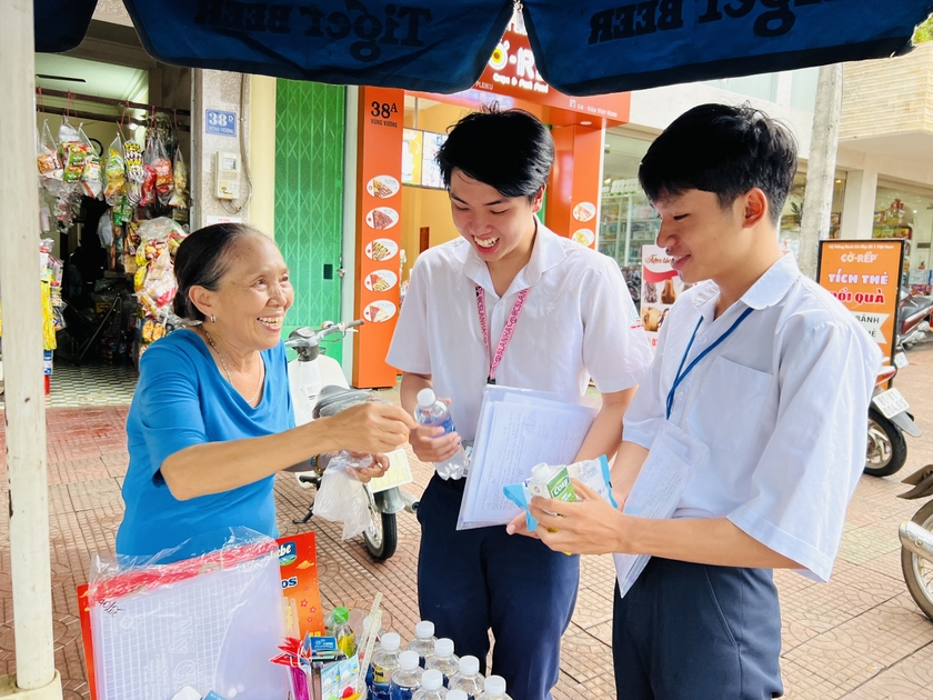 Bà Trần Thị Lý (bìa trái) tặng đồ dùng học tập cho thí sinh của điểm thi Trường THPT Phan Bội Châu. Ảnh: M.N