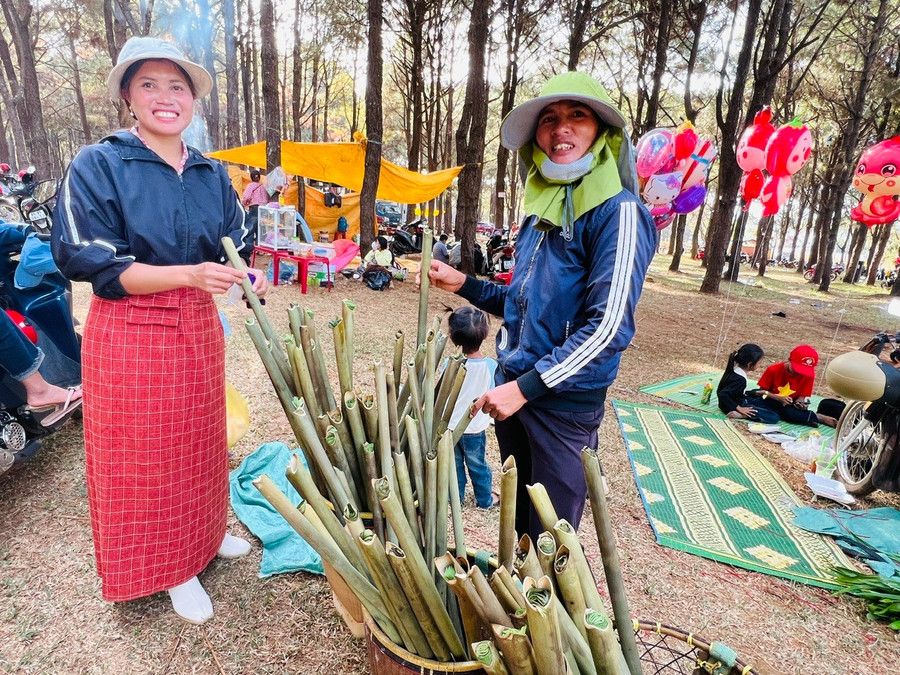 Chị Puih Boi (bìa phải, làng Klăh, xã Ia Dêr) bán cơm lam cho du khách. Ảnh: Đinh Yến z6277101107508-483c759e397118cea87924f9325331ed.jpg