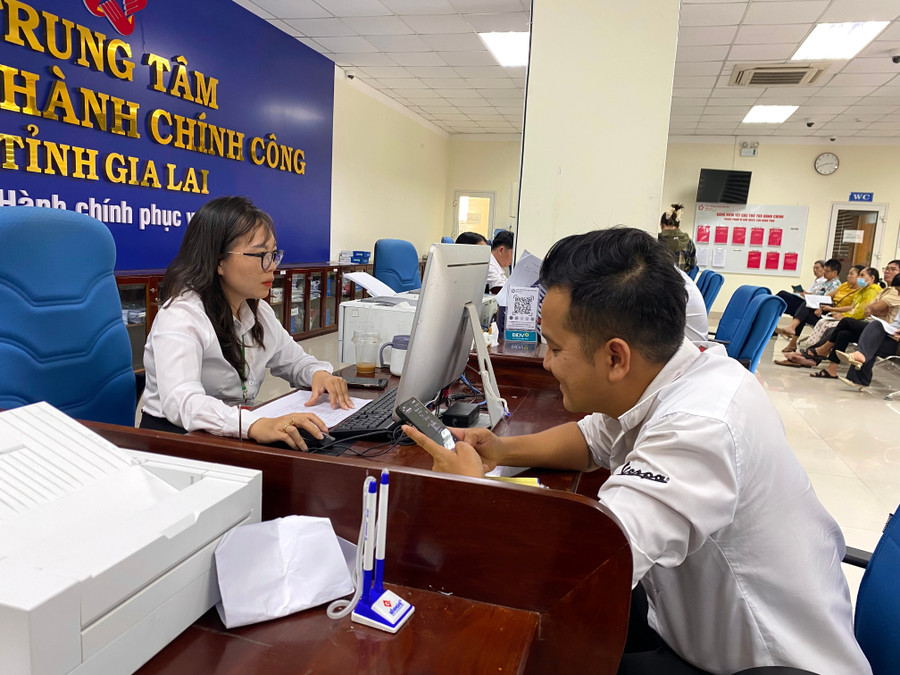 Cán bộ Trung tâm Phục vụ hành chính công phường Quy Nhơn tiếp nhận hồ sơ cấp sổ đỏ lần đầu cho người dân. Ảnh: N.C 1.jpg