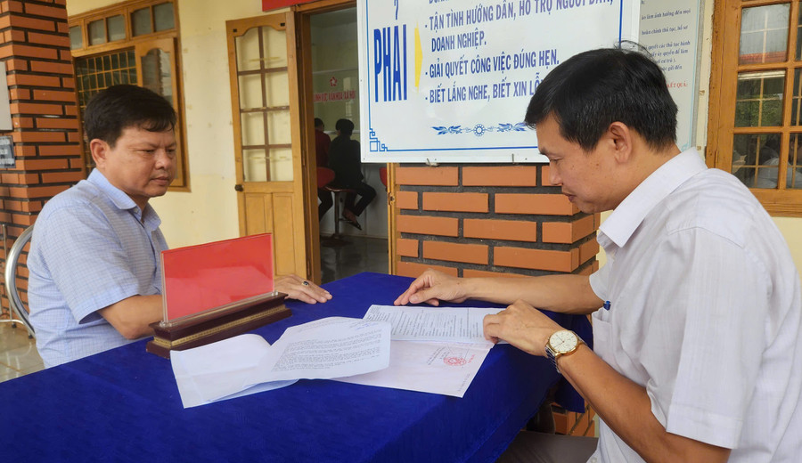 Ông Lê Quang Toản (bên phải)-Phó Giám đốc TTPVHCC xã Gào hướng dẫn người dân làm các thủ tục liên quan về đất đai. Ảnh: Ngọc Sang z6768605447572-d7ef7af4eb06a167555fe1e695353ae0.jpg