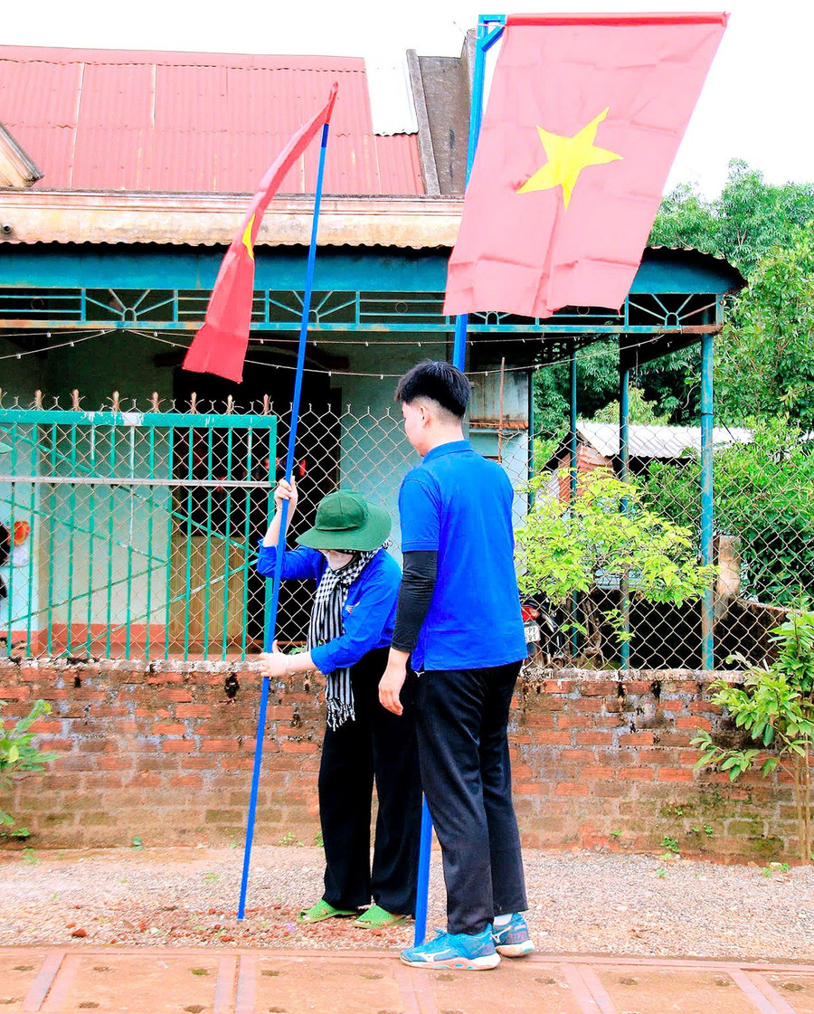 Đoàn viên, thanh niên treo cờ Tổ quốc trên tuyến đường chính của làng Ia Nhú, xã Ia Nan. Ảnh: P.L bg9-4.jpg