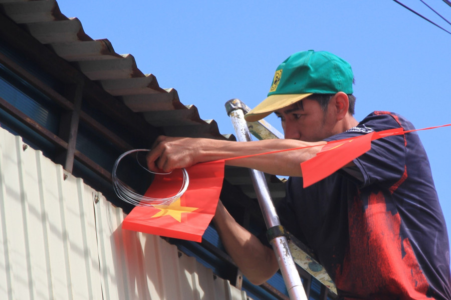 Ông Lê Văn Trung-Tổ trưởng Tổ dân phố 1-Phù Đổng-tham gia treo dây cờ trang trí cùng với người dân. Ảnh: Hoàng Hoài 1-img-0127.jpg