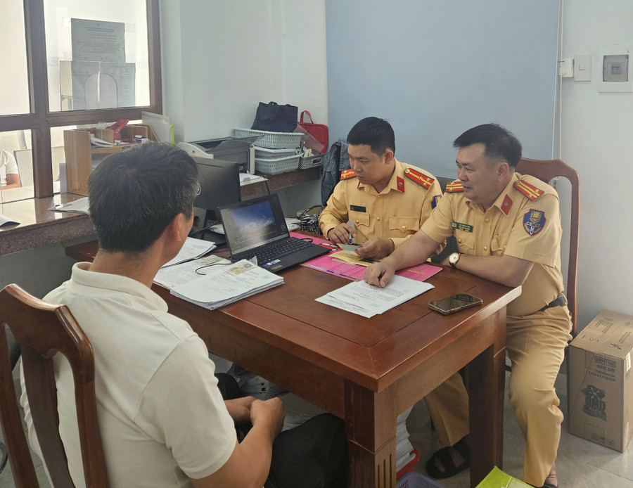 Tài xế Bùi Quang Minh làm việc với cán bộ Phòng Cảnh sát giao thông. Ảnh: ĐVCC 9.jpg