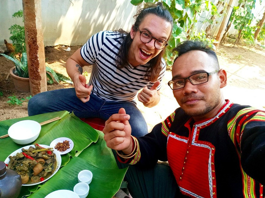 Anh Rcom Dam Mơ Ai (bìa phải) hướng dẫn nhiếp ảnh gia, nhà làm phim Stephen Parcalidis cách chế biến, thưởng thức ẩm thực của người Jrai. Ảnh: NVCC 7.jpg