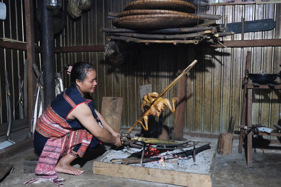 Chị Đinh Thị Nhung (làng Stơr, xã Tơ Tung) nướng gà đãi khách. Ảnh: Hoàng Ngọc dscf5130.jpg