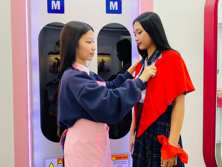 Nhân viên hỗ trợ thắt khăn quàng cho người chụp, giúp mọi người hoàn chỉnh trang phục trước khi lưu giữ khoảnh khắc ý nghĩa của sự kiện. Ảnh: Chu Hằng img-0789.jpg